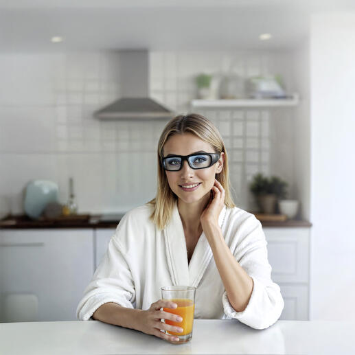 Frau mit Lichtbrille in der Küche bei der Einnahme eines Getränks.