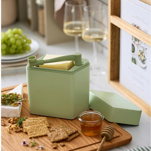 Käse Frischebox mit Schneider auf einem Holzbrett neben Crackern und Honig.