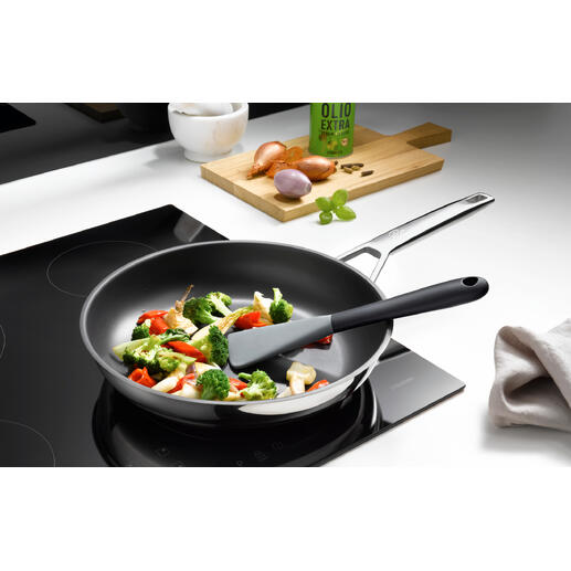 Flexibler Silikonspatel in einer Pfanne mit gemischtem Gemüse.