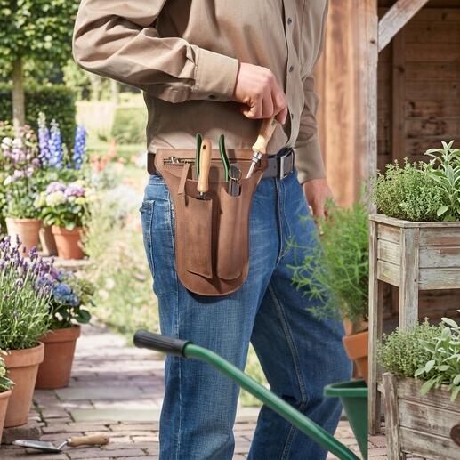 Mann trägt eine Werkzeug-Gürteltasche aus Büffelleder, gefüllt mit Gartenwerkzeugen.