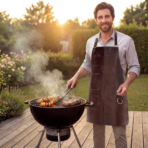 Mann grillt mit Büffelleder-Grillschürze am Grill im Garten.