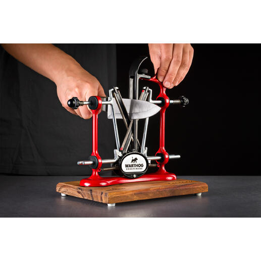 Profi-Messerschärfer in rot wird von einer Hand genutzt.