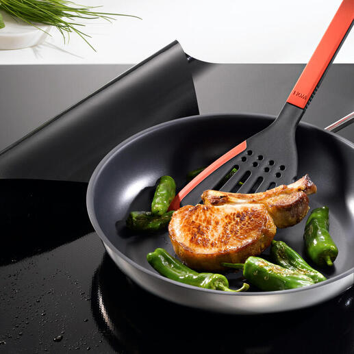 Pfanne mit Zucchini und einem Kotelett auf einem Induktions-Kochfeldschutz