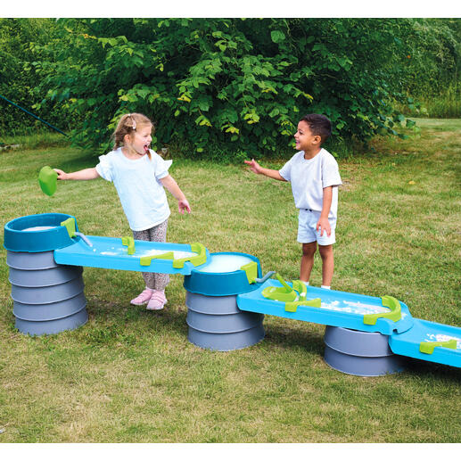 Zwei Kinder lachen und spielen an der Wasser- und Matschbahn.