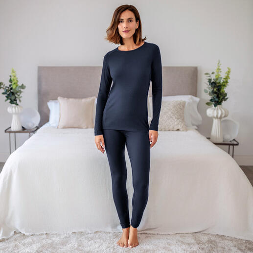 Damen-Pyjama-Shirt in Dunkelblau, lässig stehend vor einem Bett.