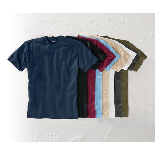 Das echte Ragman. Südamerikanische Baumwolle. 155 g/qm. Unverwüstlich und doch weich und luftig-leicht. Verschiedene Farben von Das 155 g-Ragman T-Shirt auf einem Tisch.