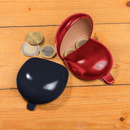 Rote und schwarze Münztasche mit geöffneter Klappe und Münzen auf einem Holztisch.
