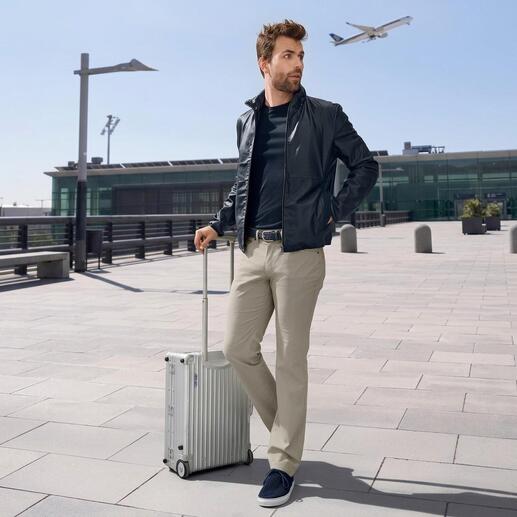 Mann in schwarzer Pocket-Lederjacke mit Koffer am Flughafen