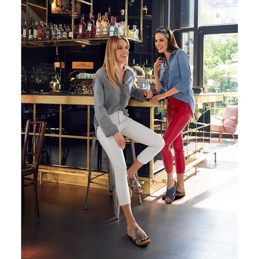 Zwei Frauen stehen an einer Bar, eine trägt eine rote Hose.