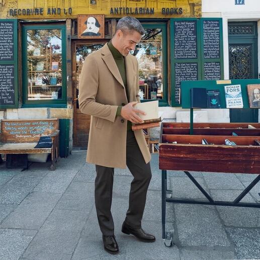 Mann in Kaschmirmantel in Beige, steht vor einem Buchladen