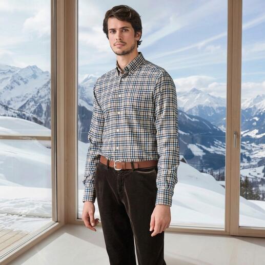 Mann in kariertem Woll-Flanellhemd vor einer Berglandschaft.