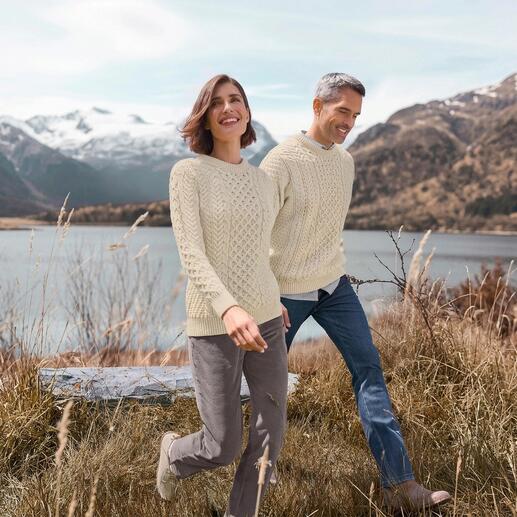 Paar in Merino-Aran-Pullis bei einem Spaziergang mit Naturhintergrund