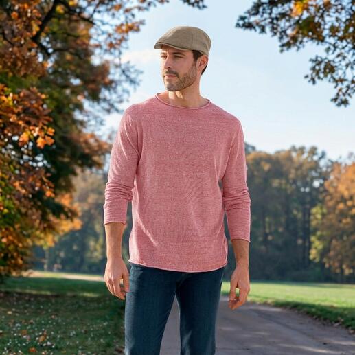 Mann in roten Pullover mit Longsleeve und Mütze in der Natur.