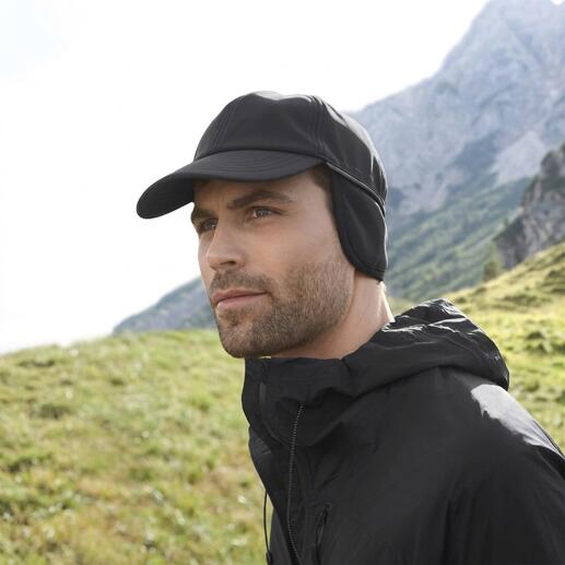 Mann mit schwarzer Softshell-Kappe und Jacke im Freien.