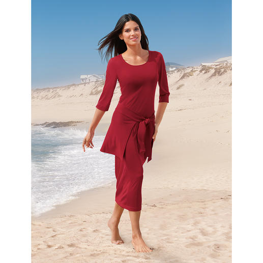 Rotes Cacheur-Kleid mit Bindegürtel an einem Strand