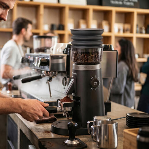 Barista mahlt Kaffeebohnen mit elektrischer Kaffeemühle im Café.