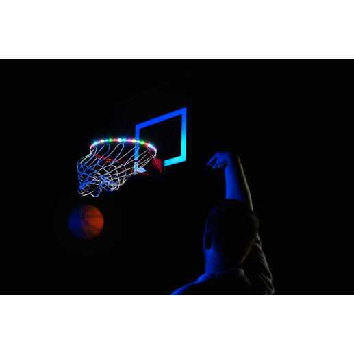 Basketballkorb mit bunten LED-Leuchten und Person beim Werfen auf einem dunklen Platz.