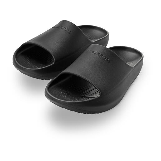 Zwei schwarze Slipper von Blackroll, seitliche Ansicht mit offenem Zehenbereich.