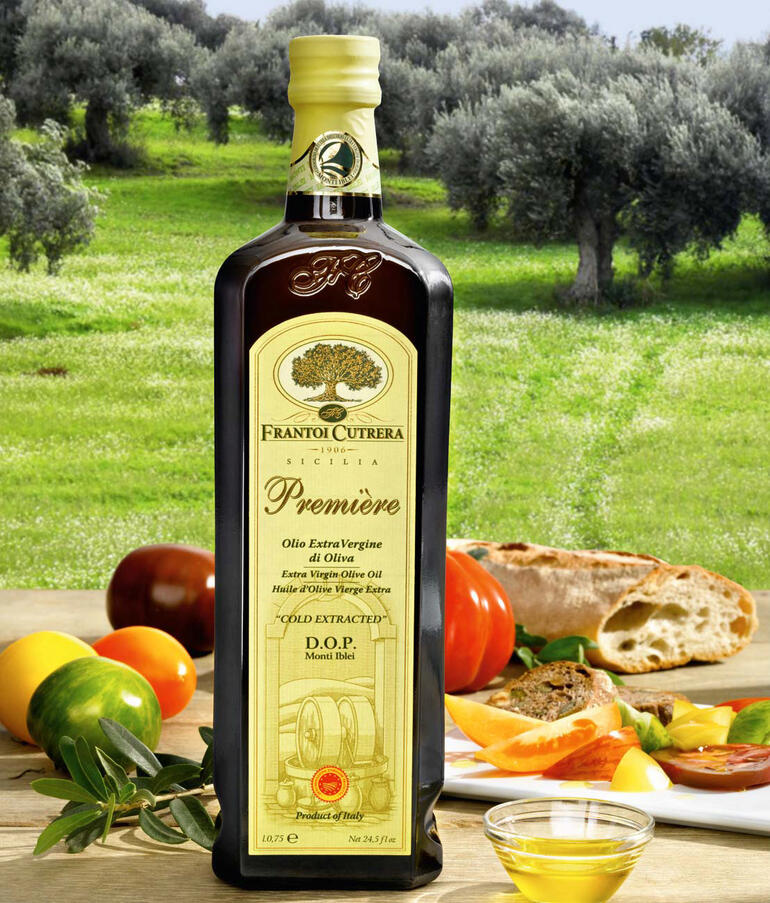 Flasche Olivenöl „Primo D.O.P Monti Iblei“ in einer sonnigen Landschaft.