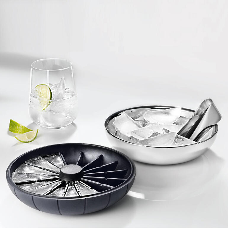 Die Silikonhaube ist gleichzeitige Eiswürfelform. 3-in-1 Eiswürfelbereiter mit Deckel, daneben ein Glas voller Eiswürfel.