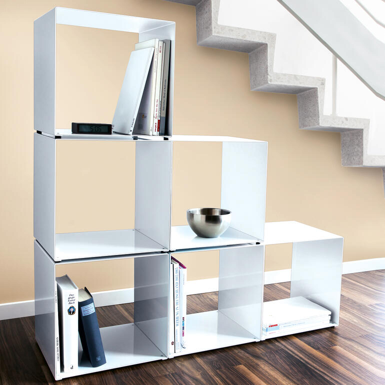 Designer-Kubus als Regal mit Büchern und einer Schüssel.