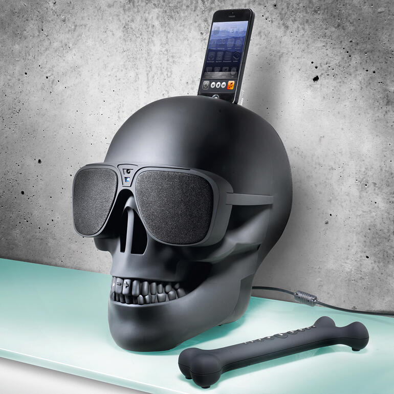Passend zum Schädel-Design: die mitgelieferte Fernbedienung im coolen Knochen-Look. AeroSkull HD in mattschwarz mit Sonnenbrille und Smartphone-Halterung.