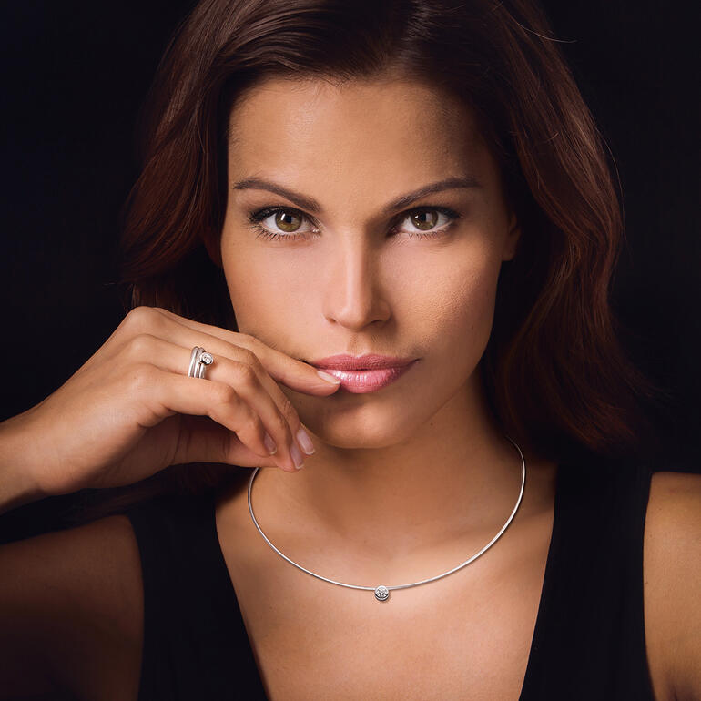 Frau trägt einen Brillant-Spiralring und ein Kabel-Collier.