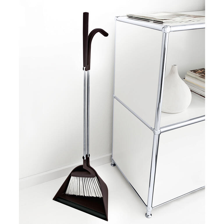 TIDY Kehrset steht in einer Ecke neben einem weißen Möbelstück.