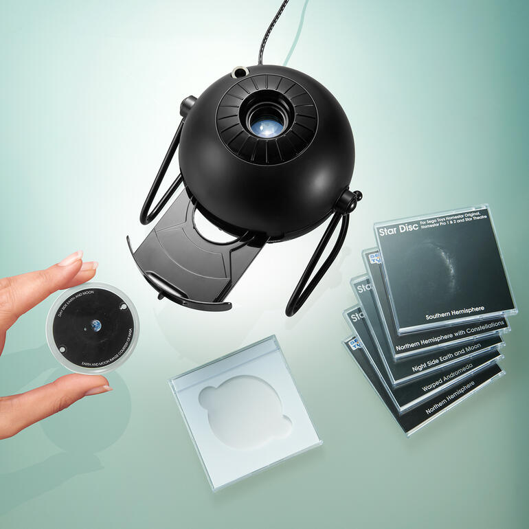 Im Nu gewechselt: Per Tastentipp öffnet sich das Gerät – bereit zum Einlegen der gewünschten Projektionsscheibe. Heimplanetarium mit Projektionsdiscs und Hand nahe der Linse.