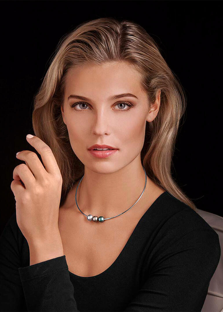 Frau kommt mit einer Tahitiperlen-Halskette näher, trägt das Stück stolz.