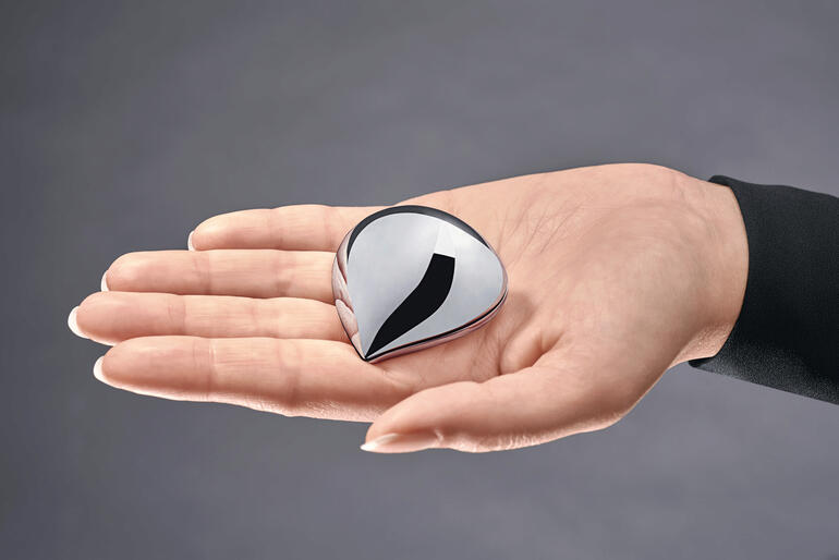 Alessi Pillendose in Form eines Wassertropfens in einer Hand