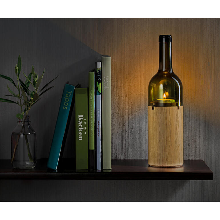 Weinlicht mit Kerze in einer Flasche auf einem Regal.