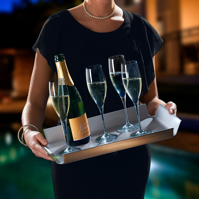 Rutschfestes Tablett in Holzoptik wird von einer Frau mit Champagner und Gläsern gehalten.