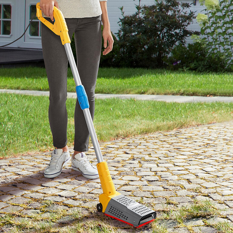 Thermoflamm bio fix Frau verwendet den Thermoflamm-Reiniger im Garten auf Pflastersteinen.