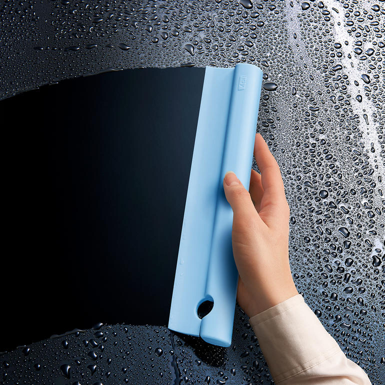 Silikon-Duschabzieher in blauer Farbe, in der Hand gehalten