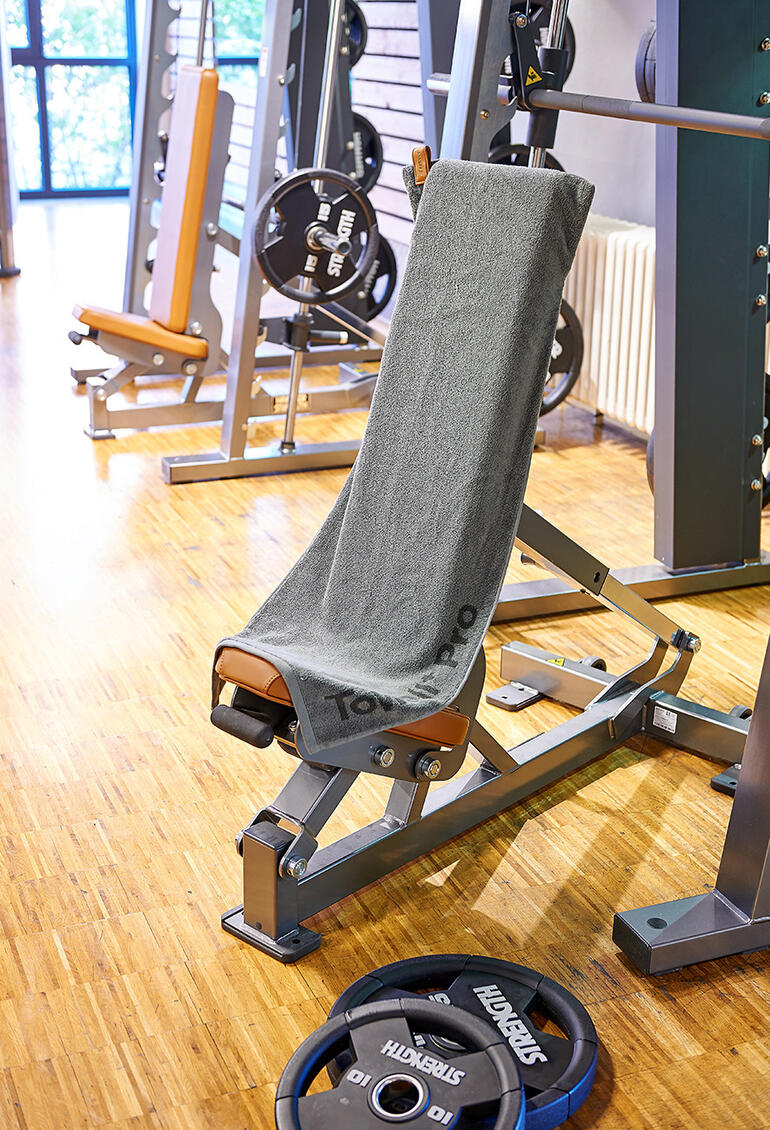 Magnetisches Sporthandtuch auf einer Trainingsbank im Fitnessstudio