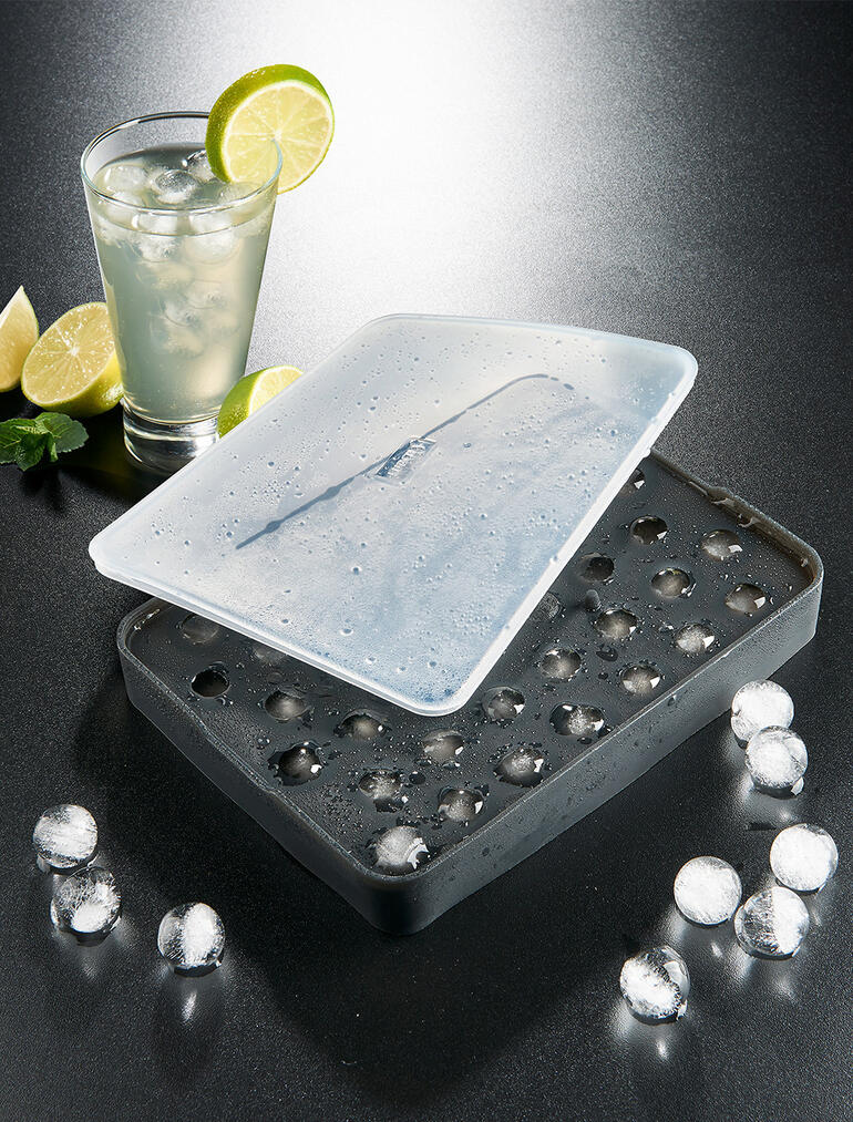 Eiskugelform mit gefrorenen Eiswürfeln und einem Getränk.