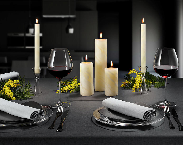 Elegante Bienenwachskerzen auf einem Tisch für ein festliches Abendessen.