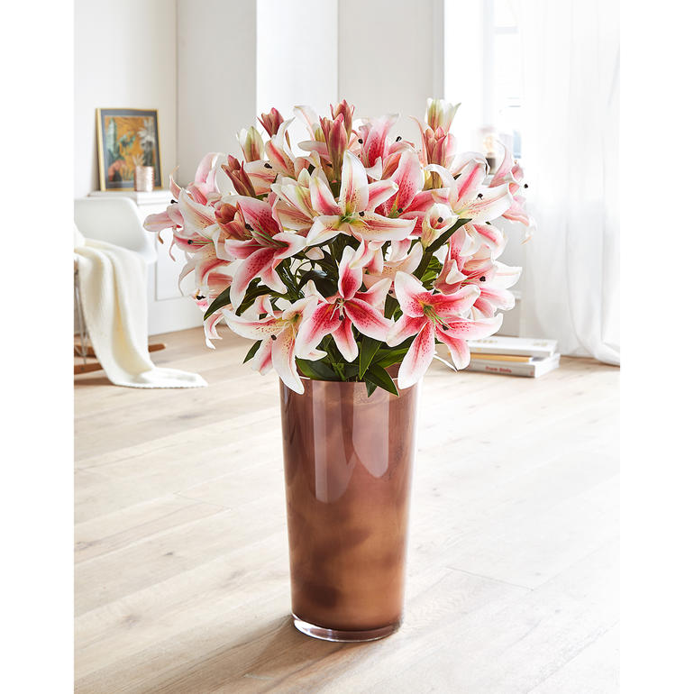 Lilienstrauß in einer kräftigen Vase im Wohnzimmer.