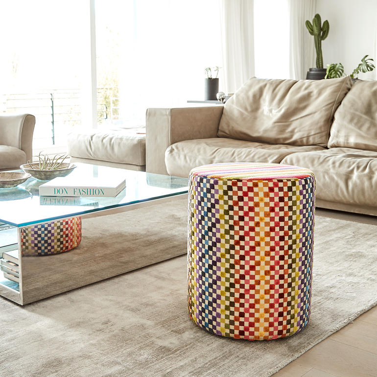 Bunter Missoni-Sitzhocker neben einem gemütlichen Sofa im Wohnzimmer.