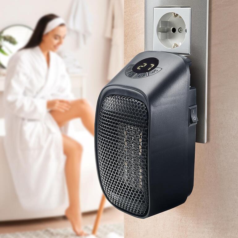 Mini-Steckdosenheizung, an eine Wandsteckdose angeschlossen, Betriebsanzeige sichtbar.