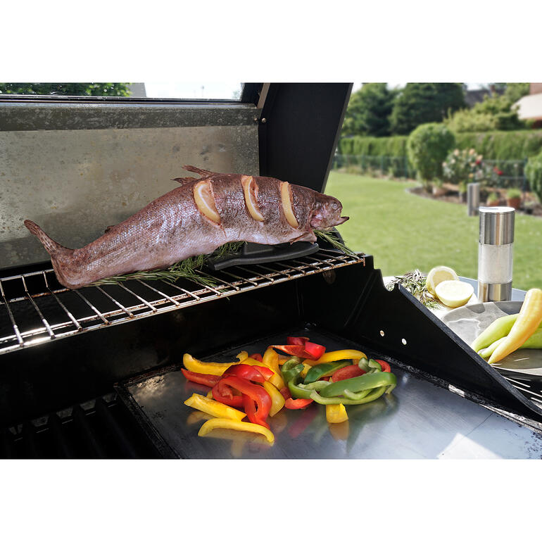 Gegrillter Fisch auf einem Grillrost mit buntem Gemüse