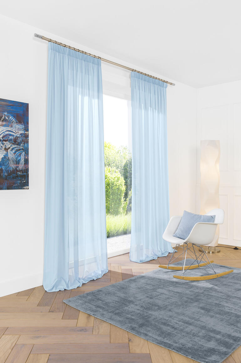 Hellblauer Vorhang, sanft fallend im Zimmer mit moderner Einrichtung.