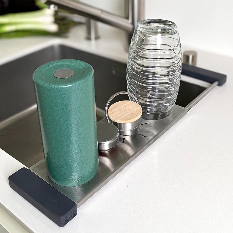 Spülbecken-Ablage mit Behältern auf der Fläche, direkt am Waschbecken.