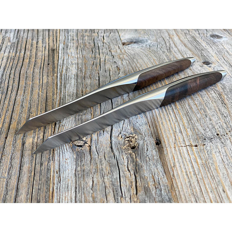 Zwei Steakmesser mit Holzgriff auf einer Holzoberfläche