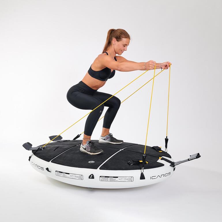Frau trainiert auf dem ICAROS Cloud mit Widerstandsbändern.