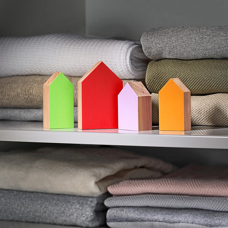 Farbenfrohe Wachhäuser in verschiedenen Formen stehen auf einem Regal.
