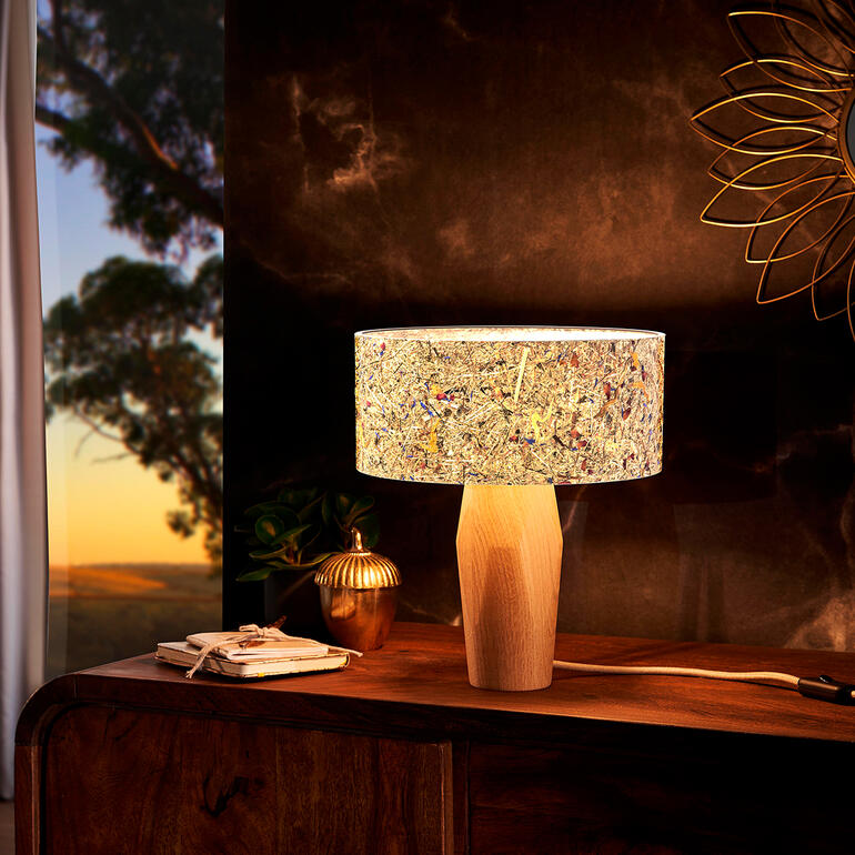 Moderne Tischlampe aus Zirbenholz mit buntem Lampenschirm auf einem Sideboard