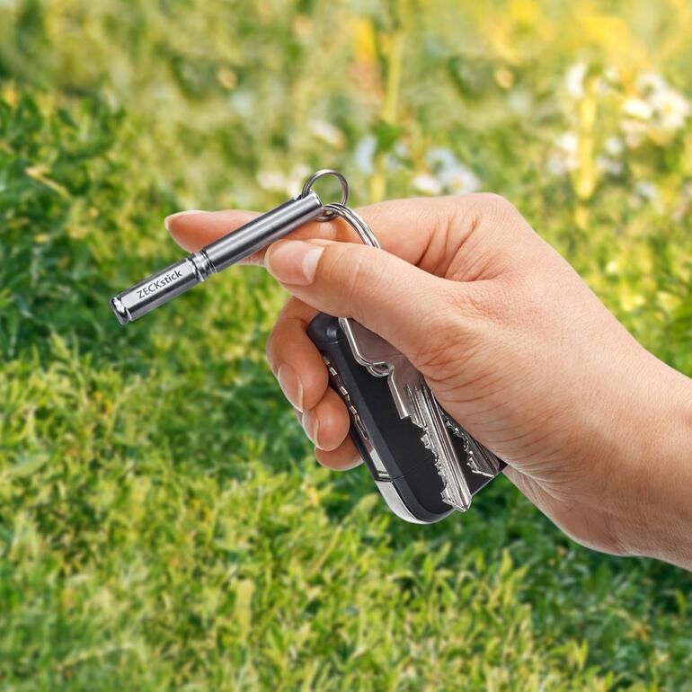 Handlich klein und immer dabei – am Schlüsselbund, Rucksack, der Gürtelschlaufe, … Hand hält ZECKstick und schwarzen Schlüsselbund im Freien.