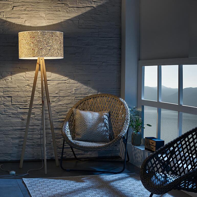 Stehlampe aus Zirbenholz mit schimmerndem Lampenschirm.